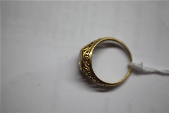 An antique scroll-pierced yellow metal ring set with an oval diamond,